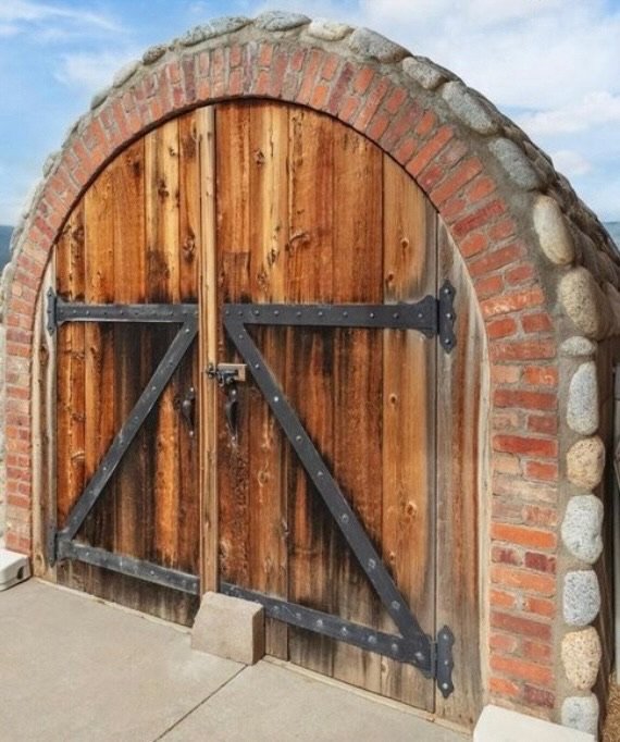 The arched timber door to the cheese aging cave