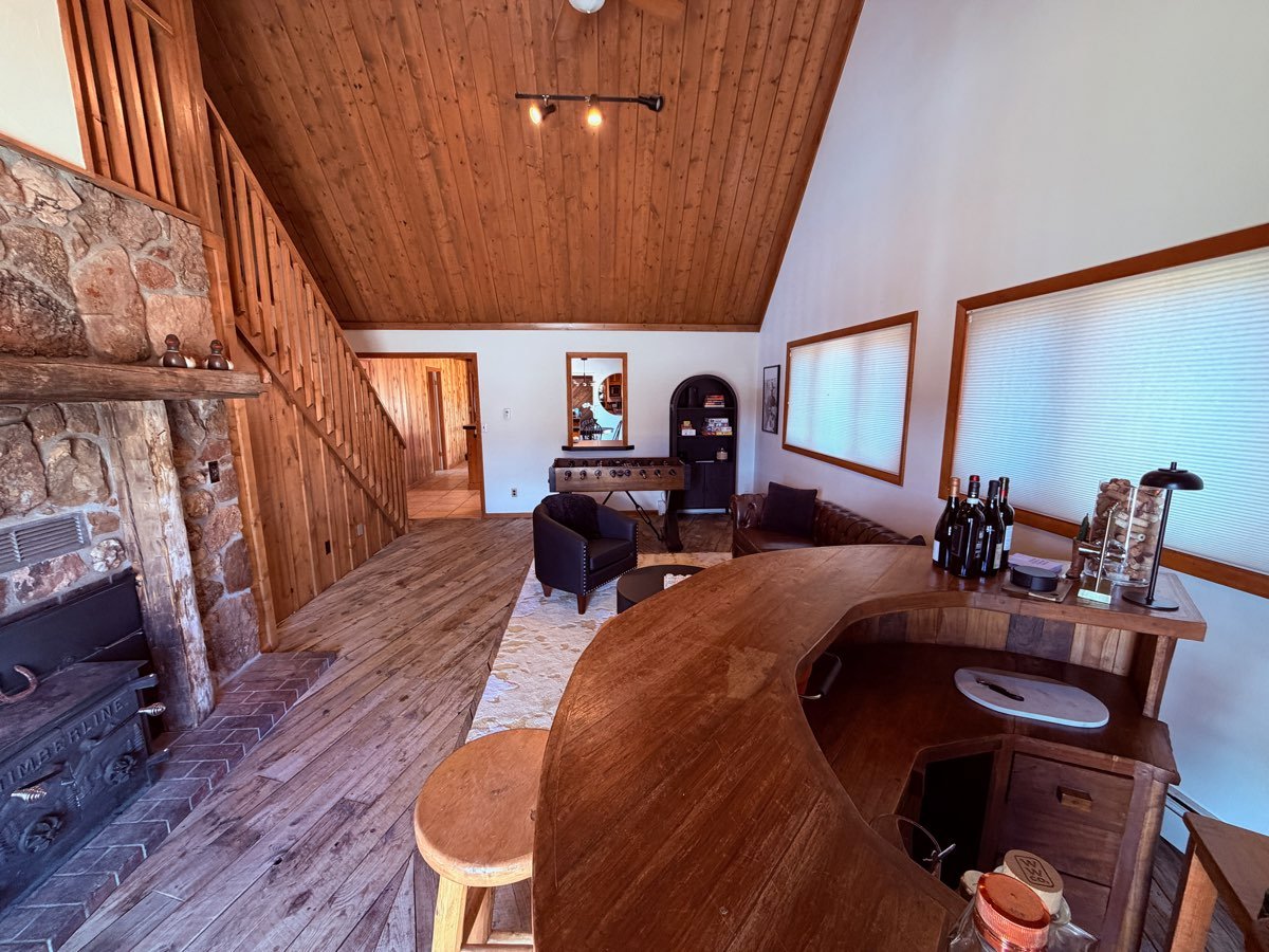 Inside the farmhouse — stone fireplace, vaulted ceilings and reclaimed-timber bar